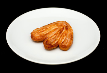 Palmier biscuit with sugar on the white plate close-up