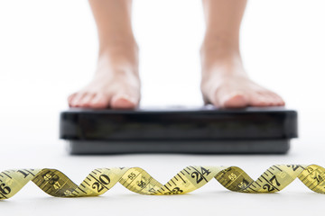 Woman standing on weight scale measure weight with isolated
