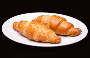 Two croissants on white plate 