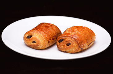 Puff pastry rolls with chocolate on white plate