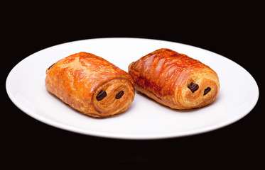 Puff pastry rolls with chocolate on white plate