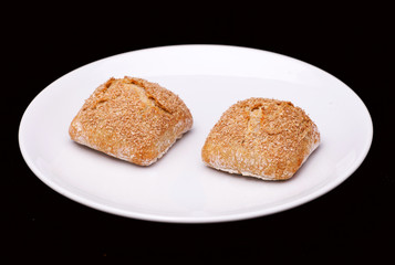 Two rye sandwich buns with cereals on white plate