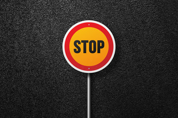 Road sign of the circular shape with the words STOP on a background of asphalt. The texture of the tarmac, top view.