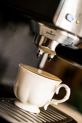 espresso machine making coffee and pouring in a white  cup