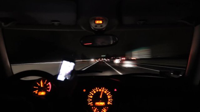texting and playing with smartphone while driving overtaking dangerously at night,inside car point of view