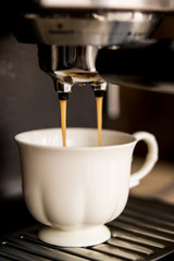 espresso machine making coffee and pouring in a white  cup
