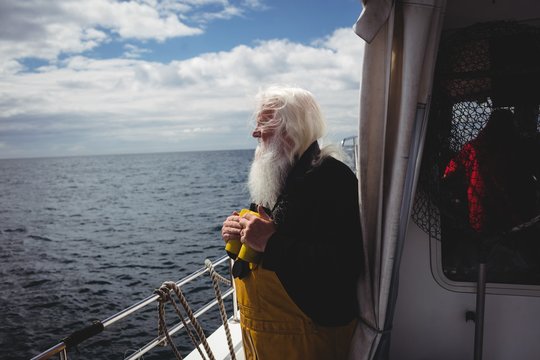Fisherman holding binoculars and looking at view