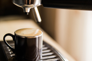 espresso machine making coffee and pouring in a brown  cup