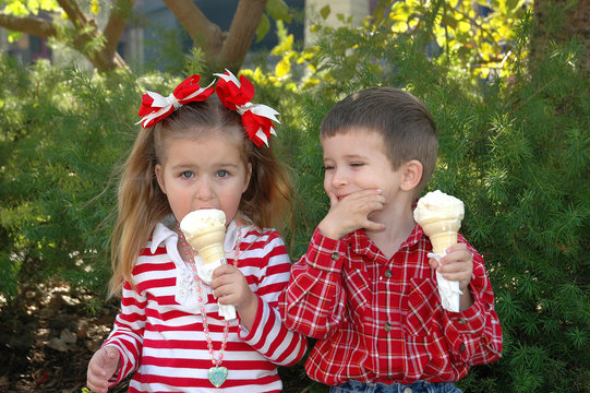 Model released image of three year old caucasian girl and four year old boy eating ice cream having fun on a cold December day in California