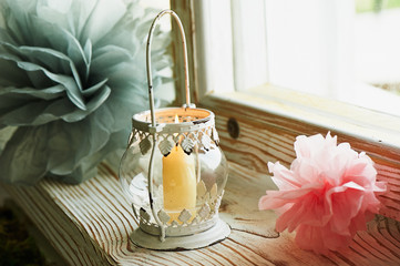 Holder white candle with Oriental ornaments with swirls, with a burning candle