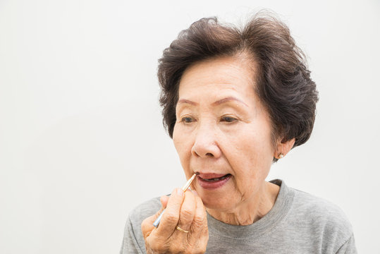 old woman applying make up