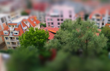 Cute toy like miniature tilt-shift effect photo of a residential housing top roof skylight windows and trees around the buildings