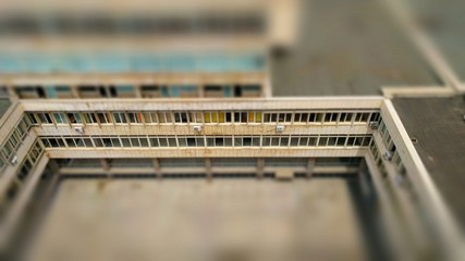 Small toy like tilt-shift effect image of inner yard with infinite modernistic ribbon windows