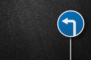 Road sign of the circular shape with pointer on a background of asphalt. Detour. The texture of the tarmac, top view.