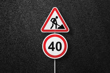 Road signs of the circular and triangular shape with a picture of a worker on a background of asphalt. Speed limit. The texture of the tarmac, top view.