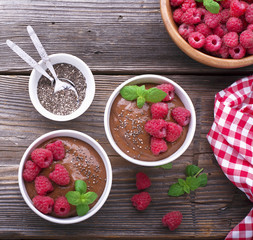 Chocolate Banana Smoothies served fresh juicy ripe raspberries with a sprig of mint in portioned bowls