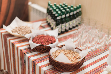 Close-up of luxurious rural-style catering table in restaurant ready for wedding celebration. Focus on salty peanuts