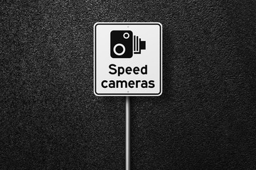 Road sign on a background of asphalt. Speed-limit cameras. The texture of the tarmac, top view.