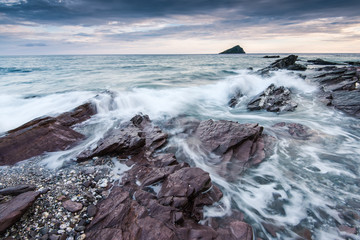 stormy and dramatic clouds over rocky beach