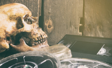 Naklejka premium Dead Skull over movie film and video tape vintage filter