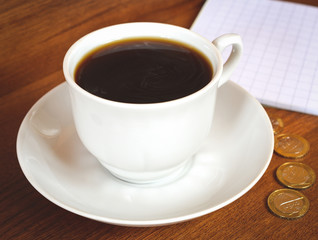 Obraz premium Coffee cup and saucer on a wooden table. Dark background.
