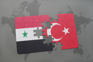 puzzle with the national flag of syria and turkey on a world map background.