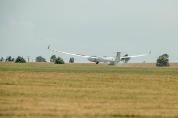 Fototapeta na wymiar The glider landed on the grassy airport.