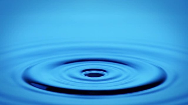 A single drop of water falling into a pool of water. Shot with a high-speed camera.