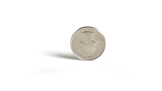A United States quarter dollar spins on a perfectly white surface. Shot with a high-speed camera.