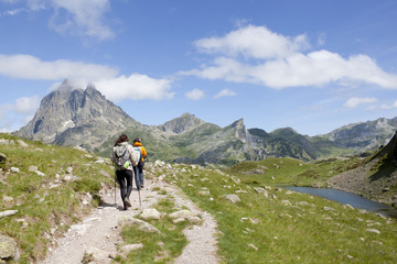 Obraz premium two hiker in front of the Midi d'Ossau and in the Ayous Lakes, Pyrenees, France