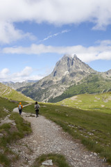 Fototapeta na wymiar Two girls hiking with the Midi d'Ossau peak behind