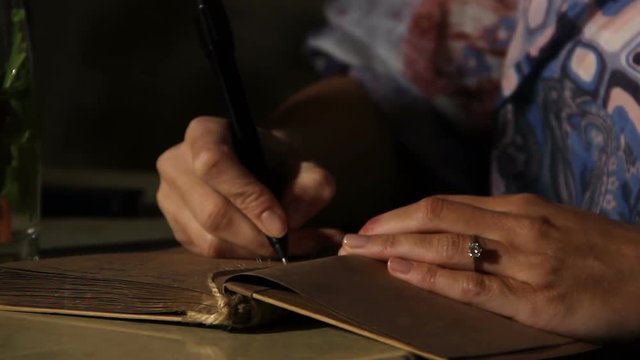 Female hands writing notes in bride diary before wedding day, big day planning