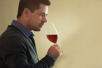 Handsome man tasting red wine