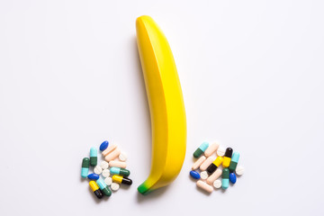 Banana with pill for impotence man - obrazy, fototapety, plakaty