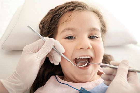 Dentist examining girl's teeth