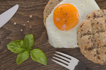 Sandwich with a fried egg on a wooden table dark.