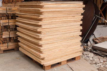 Plywood of different sizes lie on racks and pallets