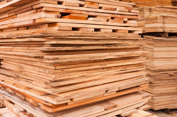 Plywood of different sizes lie on racks and pallets