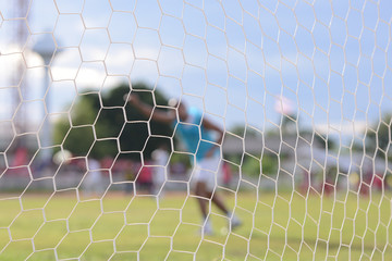 close-up net with soccer field background. blur player.