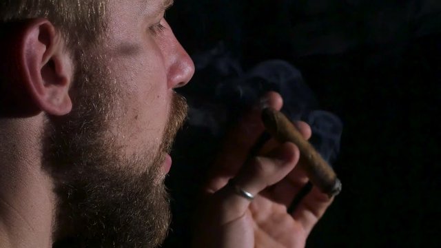 Detail of a person smoking cigar. Black. Close up