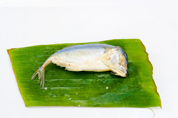 mackerel steamed on banana leaf on a white background.