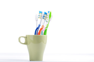 Colorful dental toothbrush in cup isolated