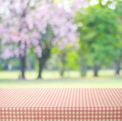 Empty table with pink tablecloth over blur park background