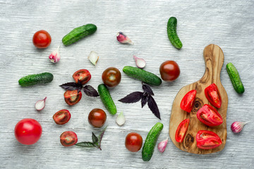 Tomatoes with basil on wooden table background. Food composition. Top view