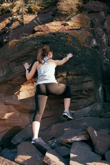 Young woman climbing the rock. 