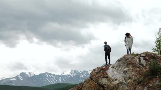 Two people standing on top of a mountain