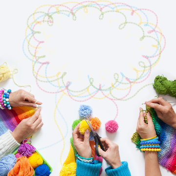 The women knit and crochet colored fabric. View from above.