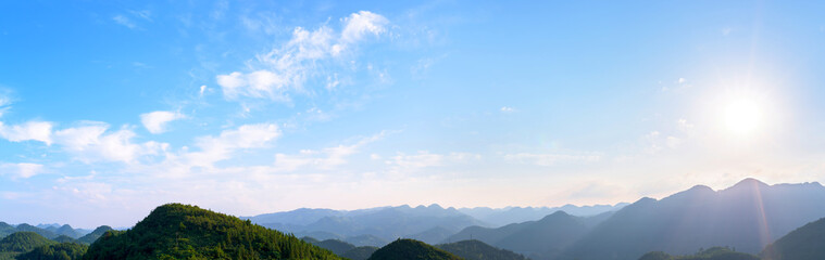 Panorama of sun flare with blue sky and mountains