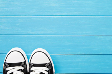 A pair of black canvas shoes on a blue wooden