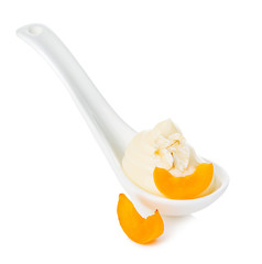Porcelain spoon of peach yogurt isolated on white.
